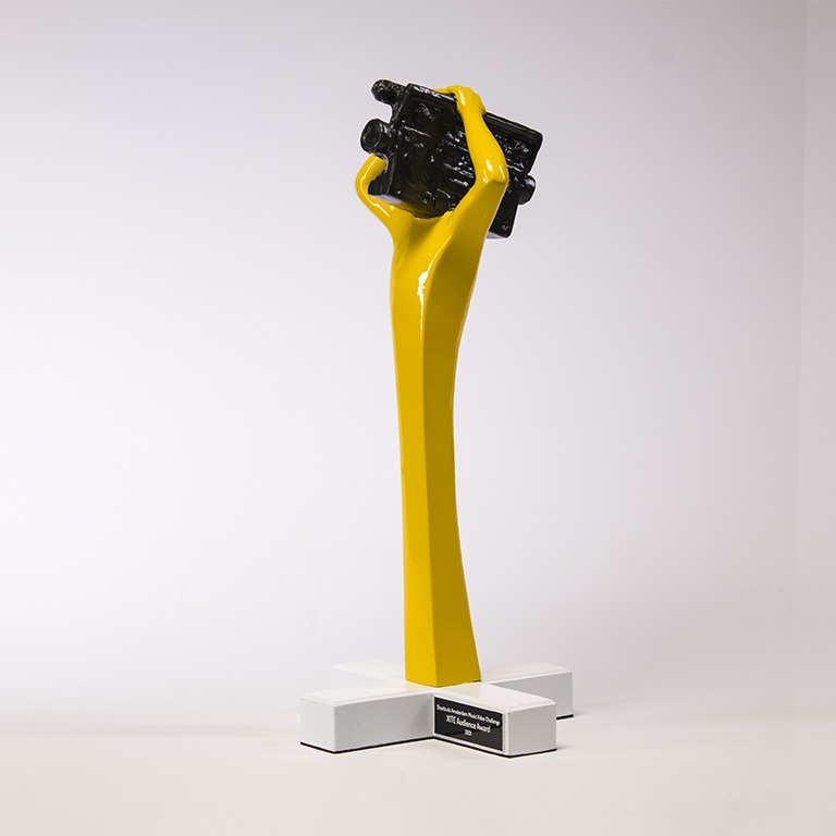 Statuetka z podstawą w kształcie litery X, nawiązująca do flagi Amsterdamu