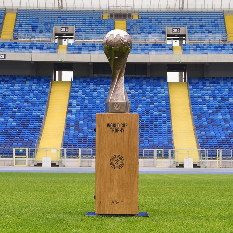 Amp Football World Cup Trophy Scultpure Trofeum z Mistrzostw Świata w Amp Futbolu, przedstawiające kulę ziemską i kule sportowe na pięciokątnej podstawie.