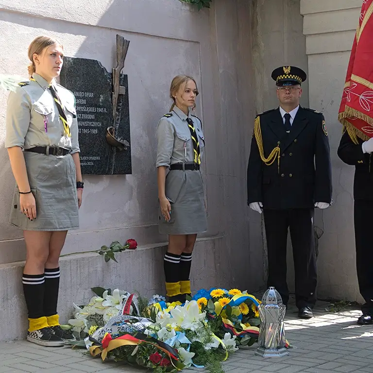 Tablica pamięci ofiar Tragedii Górnośląskiej w Chorzowie z rzeźbą karabinu i hełmu górniczego.
