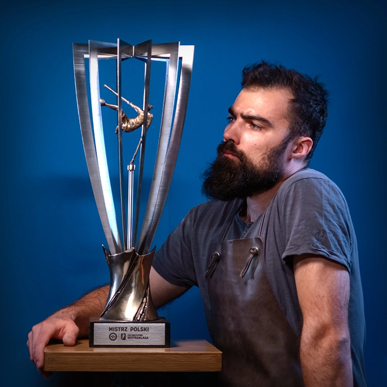 Trofeum piłkarskie – elegancka rzeźba na granitowej podstawie, ukazująca sportowca w akcji.