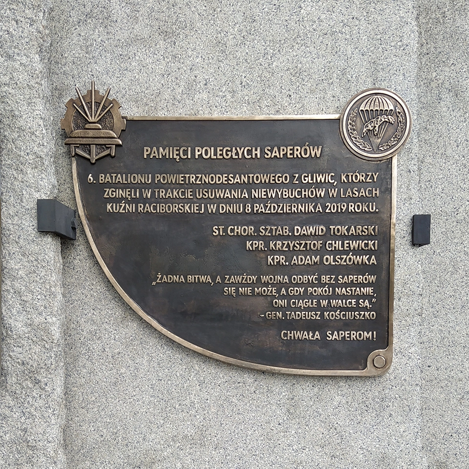 Tablica upamiętniająca tragiczne wydarzenia z 8 października 2019 roku w Kuźni Raciborskiej, z logotypami Saperów i 6. batalionu Powietrznodesantowego.
